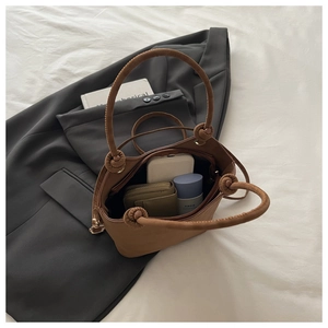 Detail view of the brown leather handbag interior space with a knotted handle design