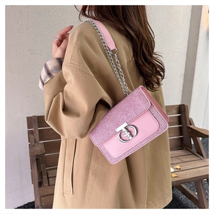 Detail of pink chain crossbody bag featuring tweed texture and silver metal lock clasp