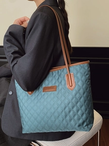 Teal quilted nylon tote bag with brown leather straps and fashion logo patch