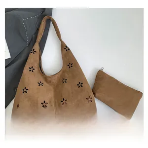 Close-up of brown suede laser-cut petal bag with matching small zippered clutch