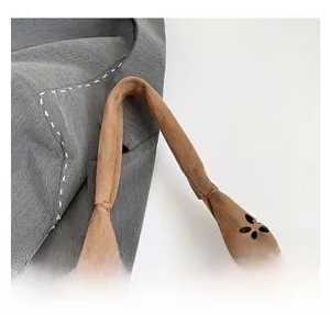 Macro detail of brown faux suede dumpling bag featuring laser-cut floral patterns
