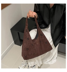 Detailed laser-cut floral pattern on a brown suede hobo tote bag for daily commute