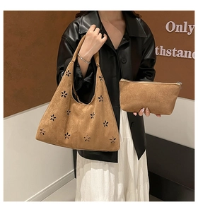 Close-up of suede dumpling bag featuring hollow flower pattern and matching inner pouch
