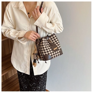 Detail of vintage quilted bucket bag with leather drawstring and cute bunny charm accessory