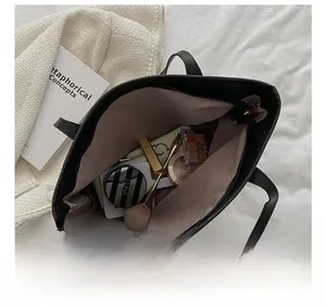 Macro view of large black tote bag interior showing ample storage for cosmetics