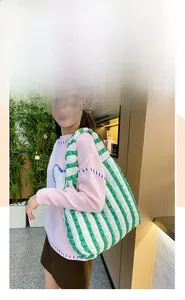 Détail du sac cabas tissé à rayures vertes et blanches avec texture en maille à bulles et anses