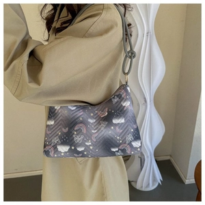 Détail du sac seau matelassé gris avec motifs de dessins animés arc-en-ciel et étoiles