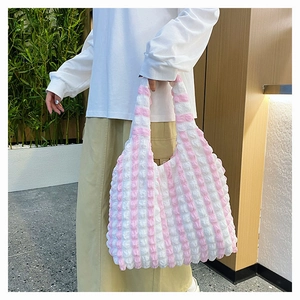 Détail de la texture d'un sac cabas à rayures roses et blanches en tissu seersucker