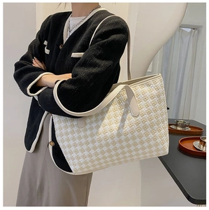 Detail of tweed large tote bag with yellow and white woven texture and shoulder strap
