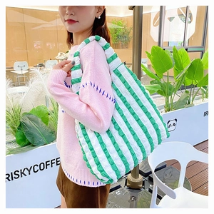 Détail du sac cabas à rayures vertes et blanches avec tissu seersucker texturé sur l'épaule