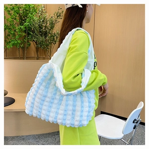 Détail du sac cabas à rayures bleues et blanches avec texture bulle et grand design