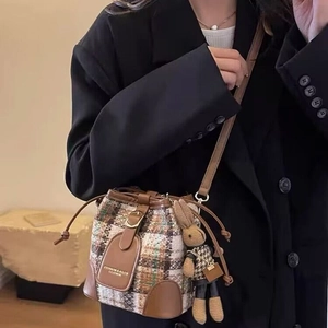 Retro plaid tweed bucket bag with leather trim and cute bunny charm on a model