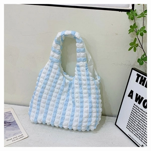 Détail du sac cabas à rayures bleues et blanches montrant la texture bulle et le plissé