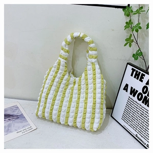 Gros plan du sac fourre-tout bouffant à rayures vert et blanc en tissu gaufré
