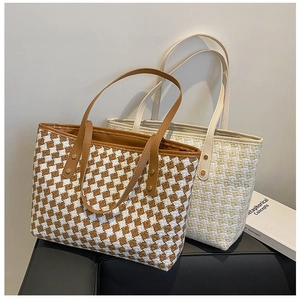 Detail view of woven tote bags with checkered pattern and durable leather handles