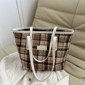 Borsa tote in lana a quadri con manici in pelle bianca su divano beige