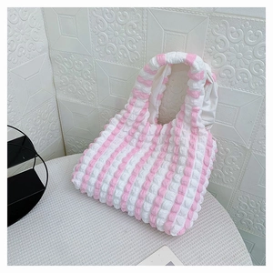 Gros plan sur la texture du tissu gaufré à rayures roses et blanches du sac cabas