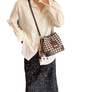 Retro checkered bucket bag with leather trim and plush charm shown on model
