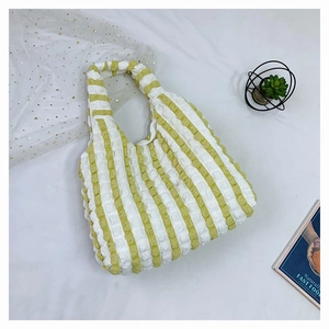 Vue détaillée du sac cabas à rayures vertes et blanches avec texture gaufrée