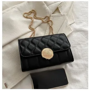 Détail du sac matelassé noir avec boucle dorée à empreinte et bandoulière chaîne