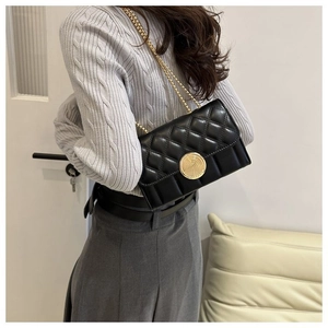 Détail du sac à bandoulière matelassé noir avec fermoir doré et bandoulière en chaîne