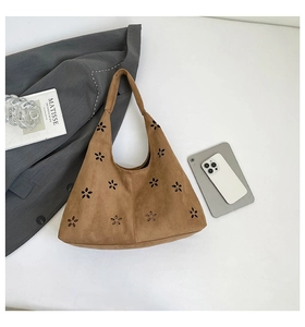 Close-up of brown faux suede tote bag with hollow petal laser-cut design and wide strap