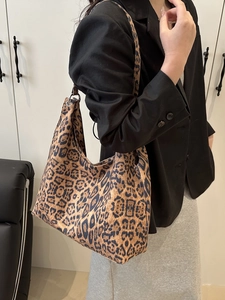 Sac fourre-tout à imprimé léopard porté par un mannequin dans un style minimaliste