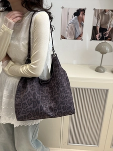 Sac hobo rétro imprimé léopard avec anneaux argentés porté par un mannequin en studio