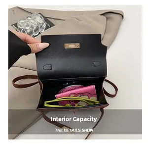 Macro shot of spacious interior for a leather handbag with daily essentials and gold buckle
