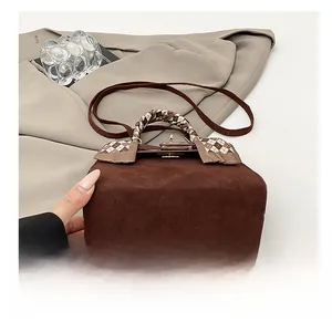 Detail of a brown frosted Kelly bag with checkered scarf handle and flat durable base