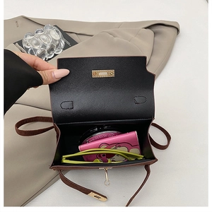 Macro view of the brown leather bag interior showing daily items and metal lock
