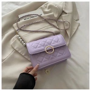 Detailansicht der lila Stepptasche mit Perlenverschluss und eleganter Perlenkette