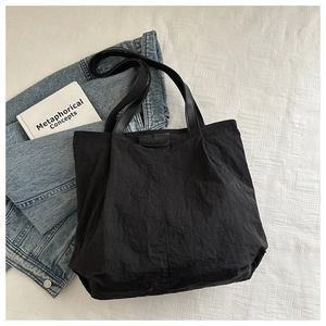 Vue détaillée du sac cabas noir en tissu froissé avec étiquette logo FASHION