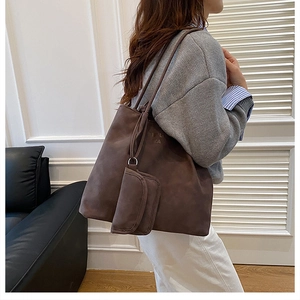 Detail of dark brown tote bag with suede texture and matching mini zipper pouch
