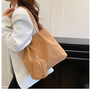 Detail of light brown PU leather tote bag with matching pouch and HYLL ZZA branding