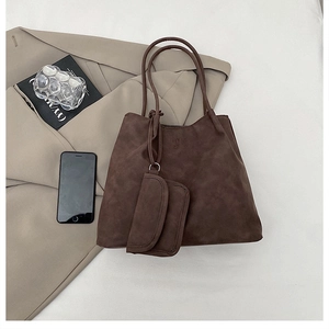 Close-up of brown tote bag set with HY 27 embossing on matte leather texture