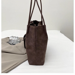 Side view of dark brown tote bag showing its wide capacity and retro matte texture
