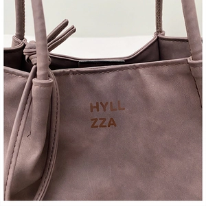 Detailed view of Morandi purple tote bag featuring HYLL ZZA logo and knotted side ties