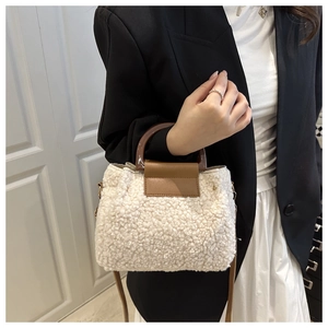 Détail du sac à main en peau de mouton avec rabat en cuir et poignée en acrylique