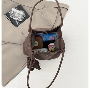 Detail view of large capacity dark brown tote bag interior with everyday essentials