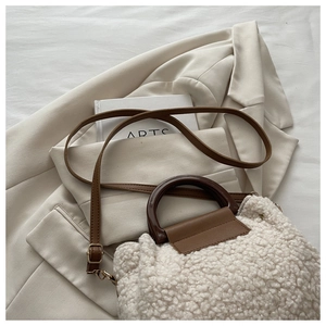 Détail du sac en peau de mouton crème avec poignée marron et bandoulière en cuir