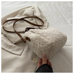 Détail du sac seau en polaire crème avec bandoulière en cuir marron et poignée