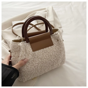 Détail du sac à main en peluche crème avec poignées marron et bandoulière en cuir