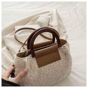 Détail du sac à main beige en peau lainée avec finitions en cuir marron et anse