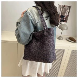 Lifestyle shot of large leopard print tote bag being worn with a denim jacket