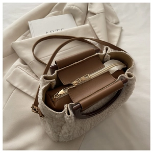 Vue détaillée du sac bandoulière en peluche beige avec double zip et doublure marron
