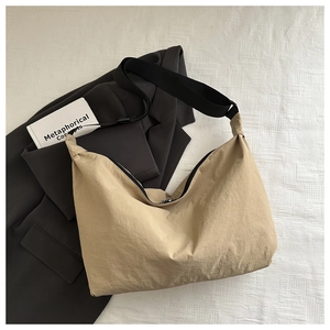 Top view of khaki nylon crescent bag with adjustable wide strap on textured background