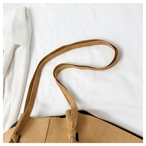 Detail view of brown matte suede tote bag showing precise stitching and knotted side design