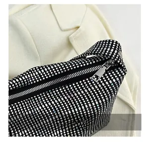 Detail shot of smooth silver zipper and sparkling rhinestones on the black handbag
