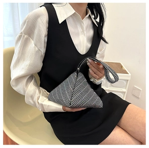 Detailed view of triangular rhinestone evening bag with checkered pattern in hand